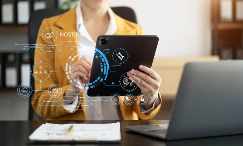 Osoba koristi tablet sa prikazom digitalnih hosting i server funkcija